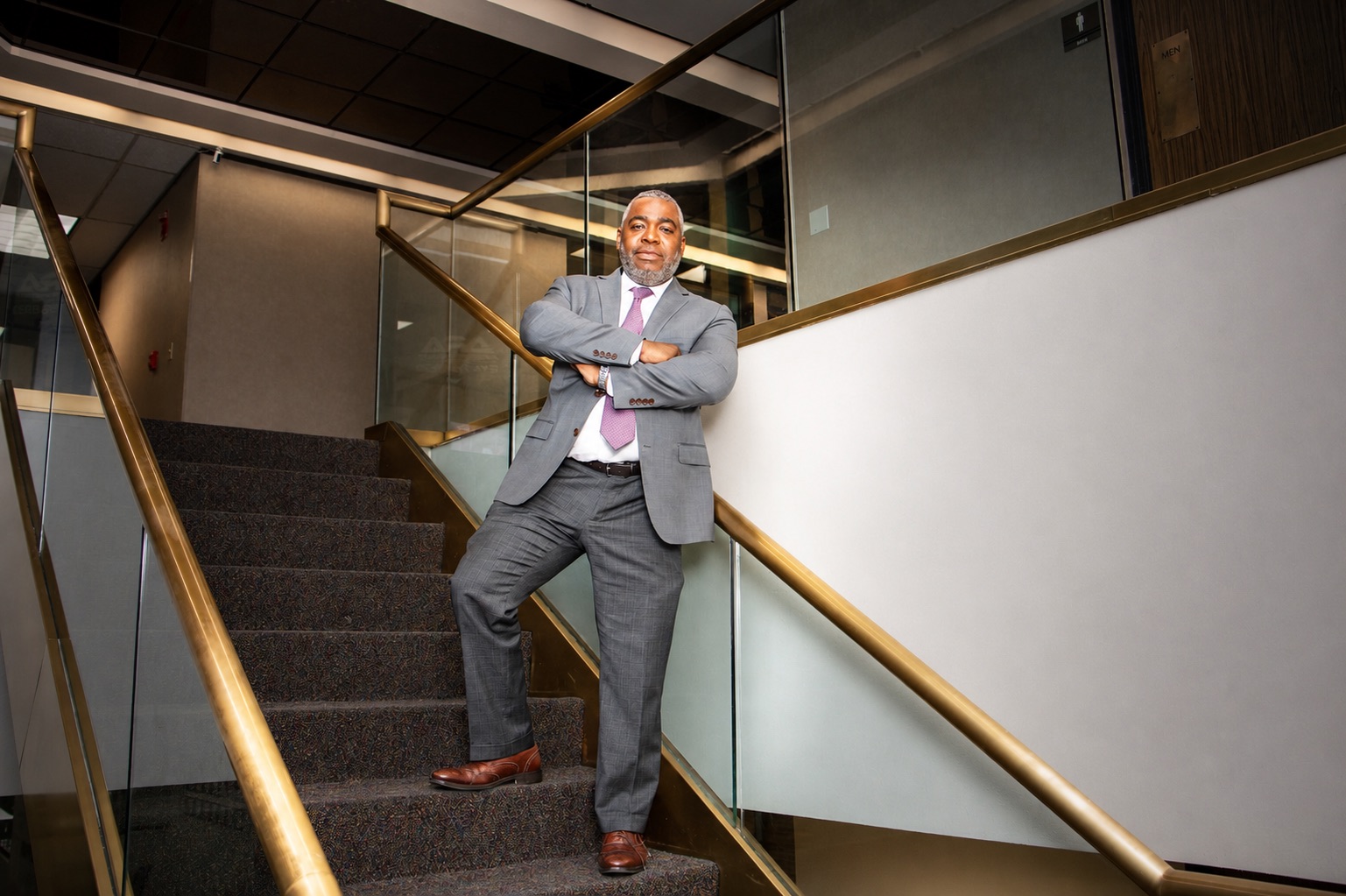 T. Christopher Lewis on a staircase in professional attire