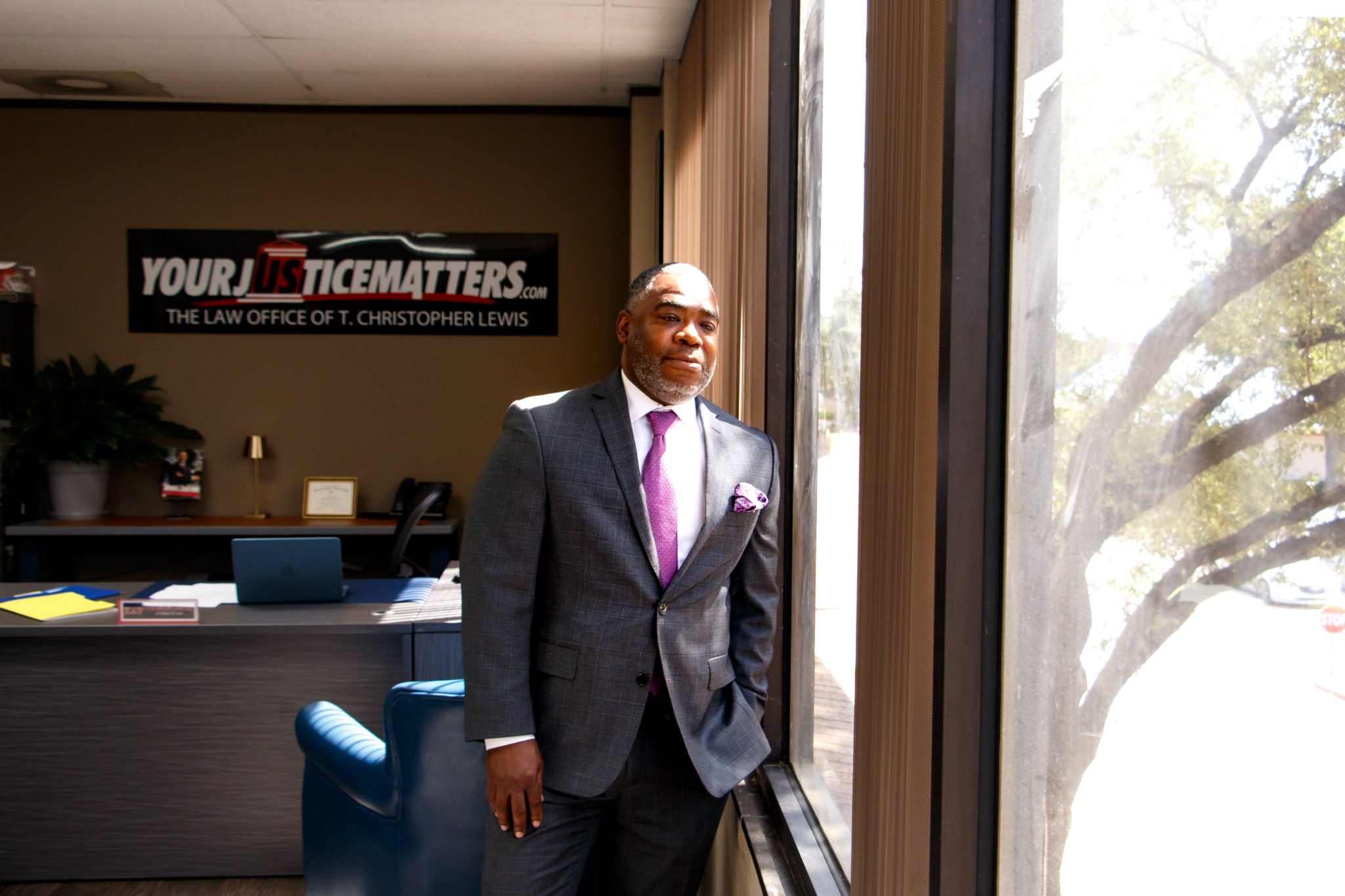 T. Christopher Lewis standing by an office window in Dallas
